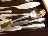 une boîte contenant de nombreuses cuillères et couteaux en argent