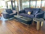 un canapé violet et deux fauteuils dans un salon