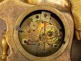 a gold clock that is sitting on top of a table