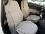 the interior of a small white car with two seats and a steering wheel