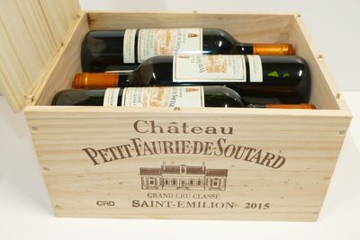 bouteilles de vin dans un coffret en bois sur une surface blanche