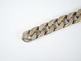 a close up of a metal bracelet on a white surface