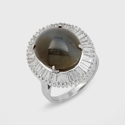 un gros plan d'une bague ornée d'une pierre noire entourée de pierres taillées en baguette