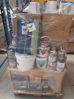 de nombreux pots de peinture posés sur un chariot dans un entrepôt