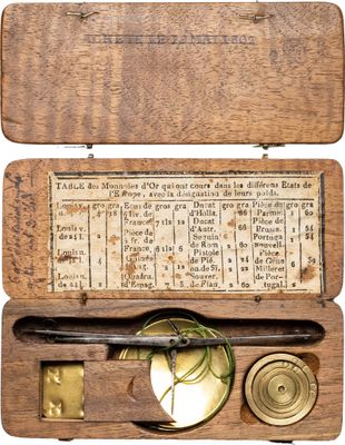une vieille boîte en bois munie d'une plaque en laiton et contenant une boussole