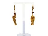 une image représentant une paire de boucles d'oreilles en or ornées d'un oiseau