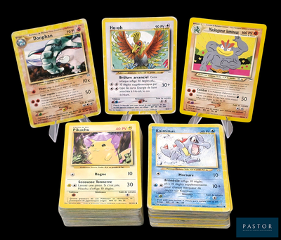 Quatre cartes Pokémon sont posées les unes sur les autres sur une table.