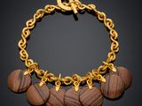 a gold bracelet with wooden discs and a gold chain