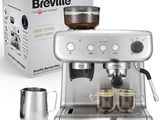 une machine à café Brevillel avec deux tasses de café devant une boîte