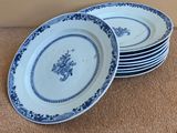 quatre assiettes ornées de motifs bleus et blancs, posées sur un tapis