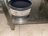a stack of plates on a metal shelf in a kitchen