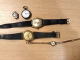 trois montres et un bracelet de montre posés sur une table en bois