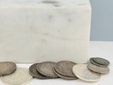 quelques pièces de monnaie sont posées à côté d'un bloc de marbre sur une table