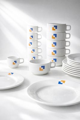 beaucoup d'assiettes et de tasses blanches sur la table