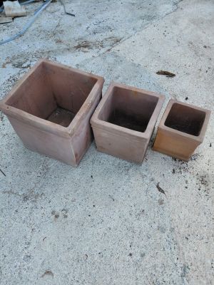 deux pots marron posés par terre l'un à côté de l'autre