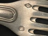 a close up of a metal fork on a black surface