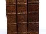 four old books stacked on top of each other on a white surface