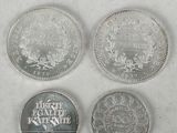 four different types of silver coins on a white surface