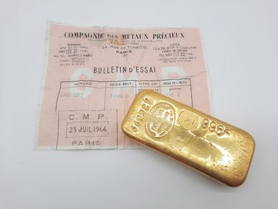 un vieux lingot d'or posé à côté d'un ticket de caisse sur une table