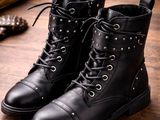 a pair of black leather boots on a wooden table