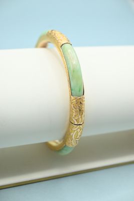 a close up of a gold ring with green jade inlay