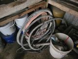 un seau d'eau et un tuyau d'arrosage dans un coin de la pièce