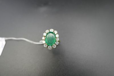 une bague en émeraude et diamant sur une surface noire