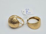 two gold rings on a white surface with a price tag