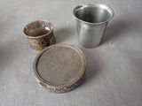 a silver cup and a silver plate sitting on a table