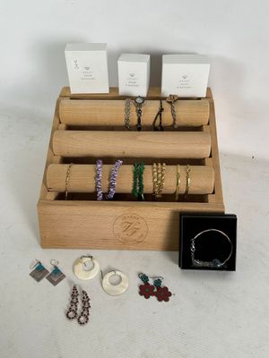 a wooden display case with a variety of jewelry on it