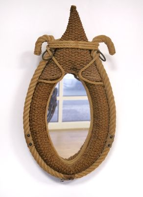 un miroir entouré d'une corde, accroché au mur