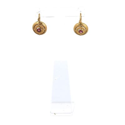 gros plan d'une paire de boucles d'oreilles sur une surface blanche