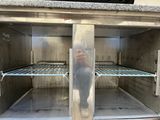 a person taking a picture of the inside of a stainless steel oven