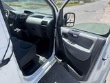 La porte d'une camionnette blanche est ouverte sur le bord de la route