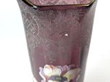 a purple vase with a floral design on it