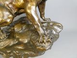 a bronze statue of a dog on a rock