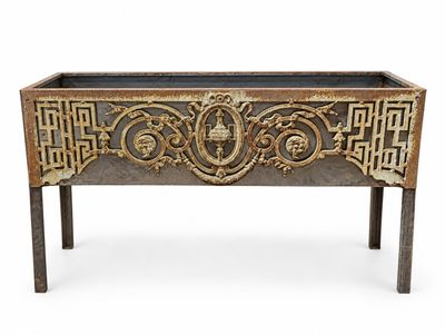 une grande jardinière en métal ornée de motifs décoratifs sur les côtés
