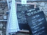 a blackboard with a menu on it sitting on the ground