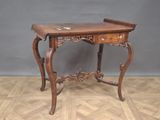 a small wooden table with drawers on it