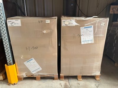 deux cartons posés sur des palettes dans un entrepôt