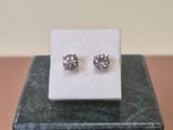 a pair of earrings sitting on top of a marble block