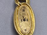 a close up of a gold wrist watch with a chain around it