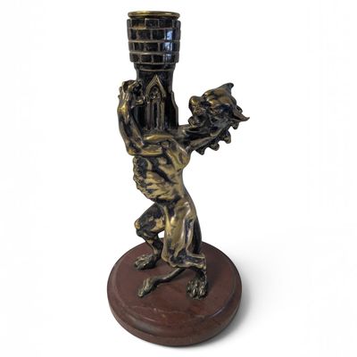 une statue représentant un homme tenant un vase, posée sur un socle