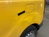 a close up of a yellow truck parked in a garage