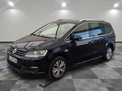 La Volkswagen Touran est garée dans une grande pièce au sol carrelé d'un motif à damier.