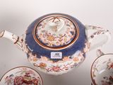 a blue and white teapot with a cup and saucer