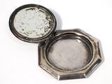 a small silver box with a silver lid on a white surface