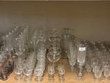 many empty wine glasses on a shelf in the kitchen