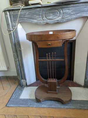 a small table with a lamp on it in front of a fireplace