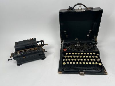une vieille machine à écrire posée à côté d'une autre vieille machine à écrire
